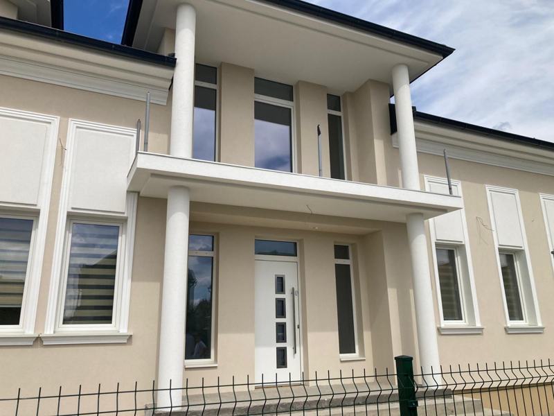 Kuća u Sremskoj Mitrovici sa bež fasadom i belim okruglim stubovima